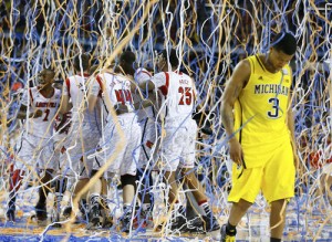 Michigan Burke walks off the court as Louisville celebrates defeating Michigan to win the NCAA men's Final Four championship basketball game in Atlanta